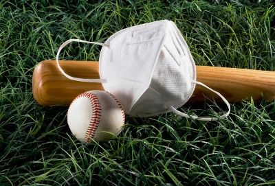 A baseball, baseball bat and face mask lie on grass - minor league baseball