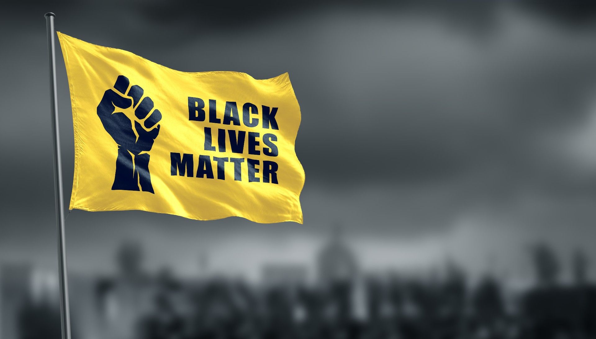 A graphic of a yellow Black Lives Matter flag flying against a grey sky