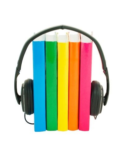 Five books with solid-color covers stand vertically between between a set of headphones - Audible free trial