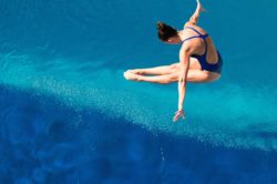 Female diver in mid air over water