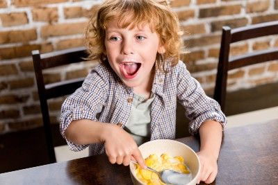 A child is happy to be eating cereal - Feeding Our Future