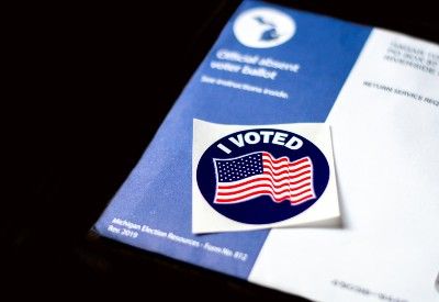 An "I voted" sticker lies on top of a mail-in ballot for Michigan - Trump campaign