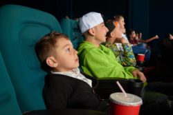 Boys sit in movie theater seats