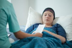 Young woman cancer survivor in hospital bed