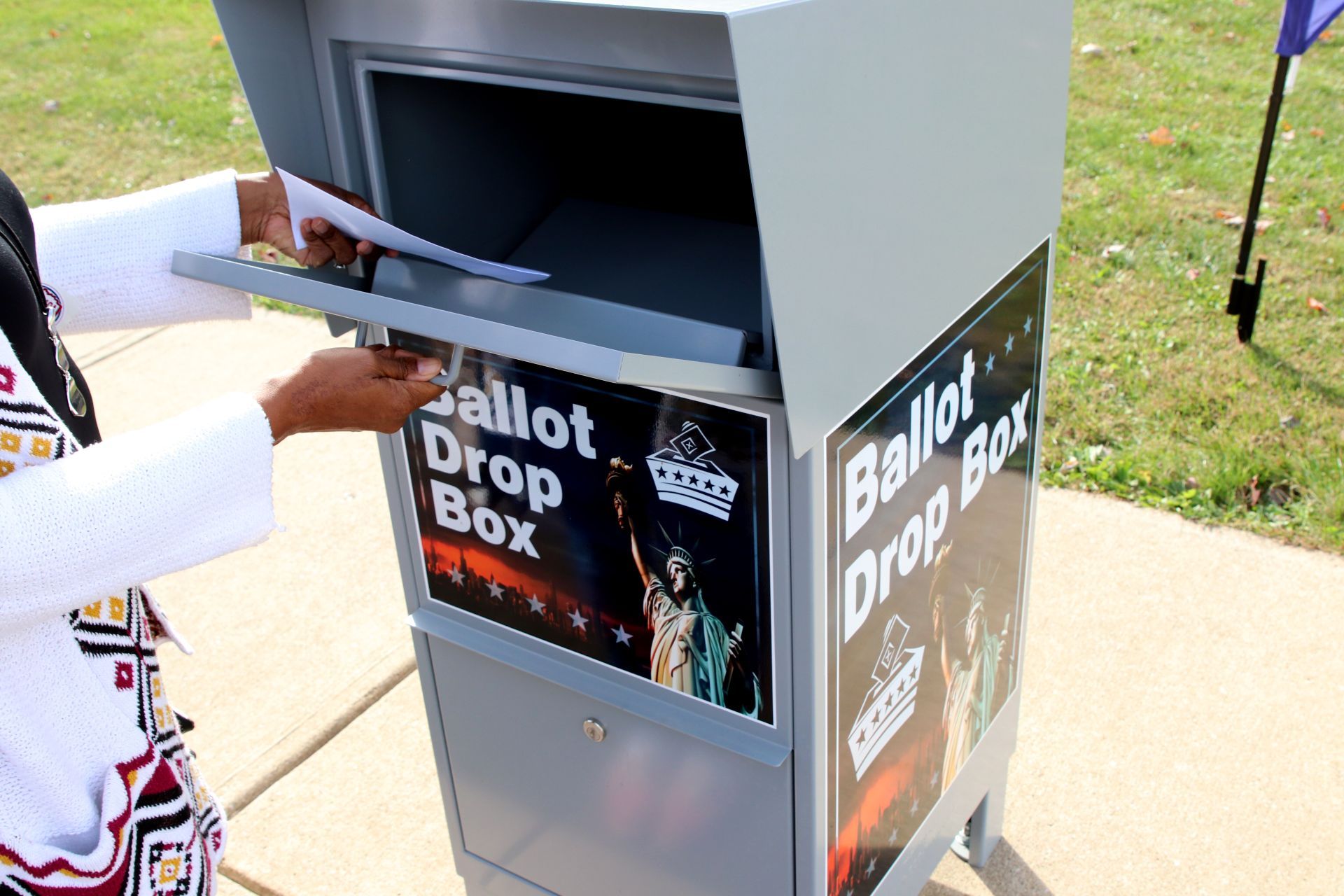 A voter drops a ballot in a drop box - Georgia voters