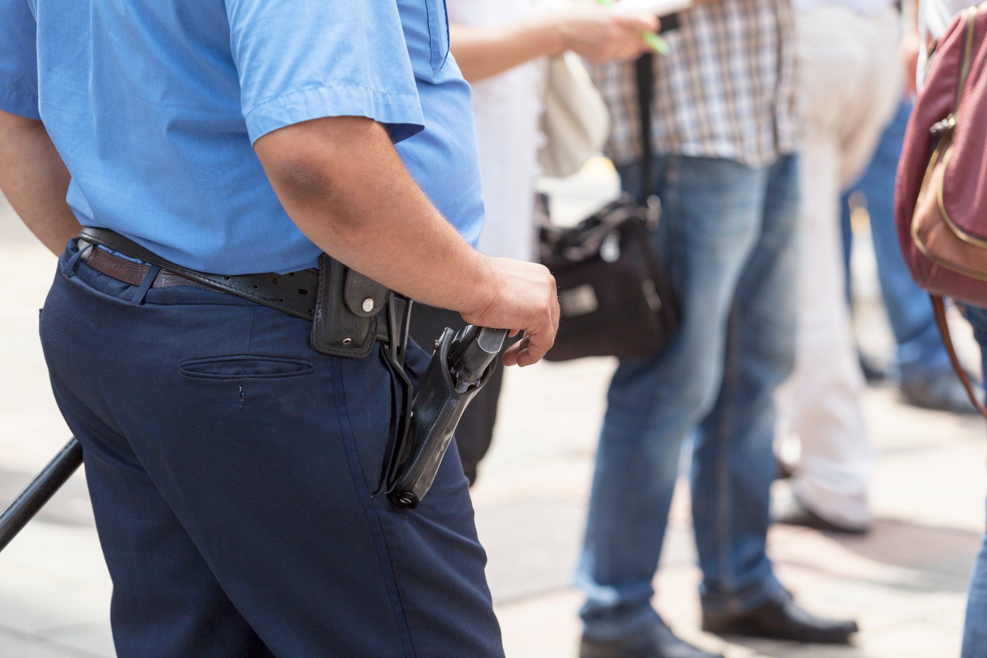 A police officer stands with his hand on his gun in its holster - police brutality