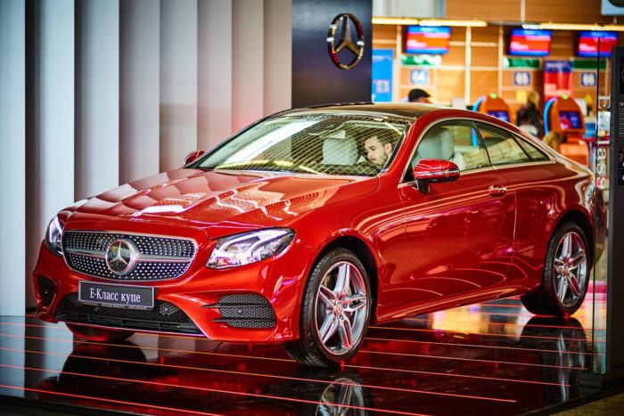 A red Mercedes-Benz coupe in a showroom - Mars Red paint