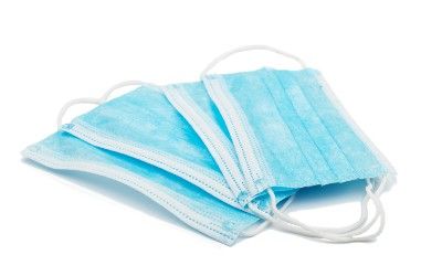 Blue surgical masks are fanned out on a white background - sales tax
