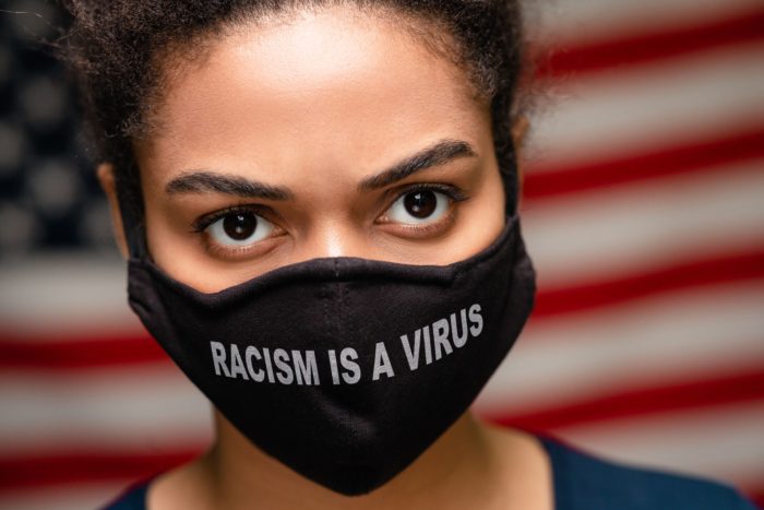 a peaceful protester wearing racism is a virus face mask