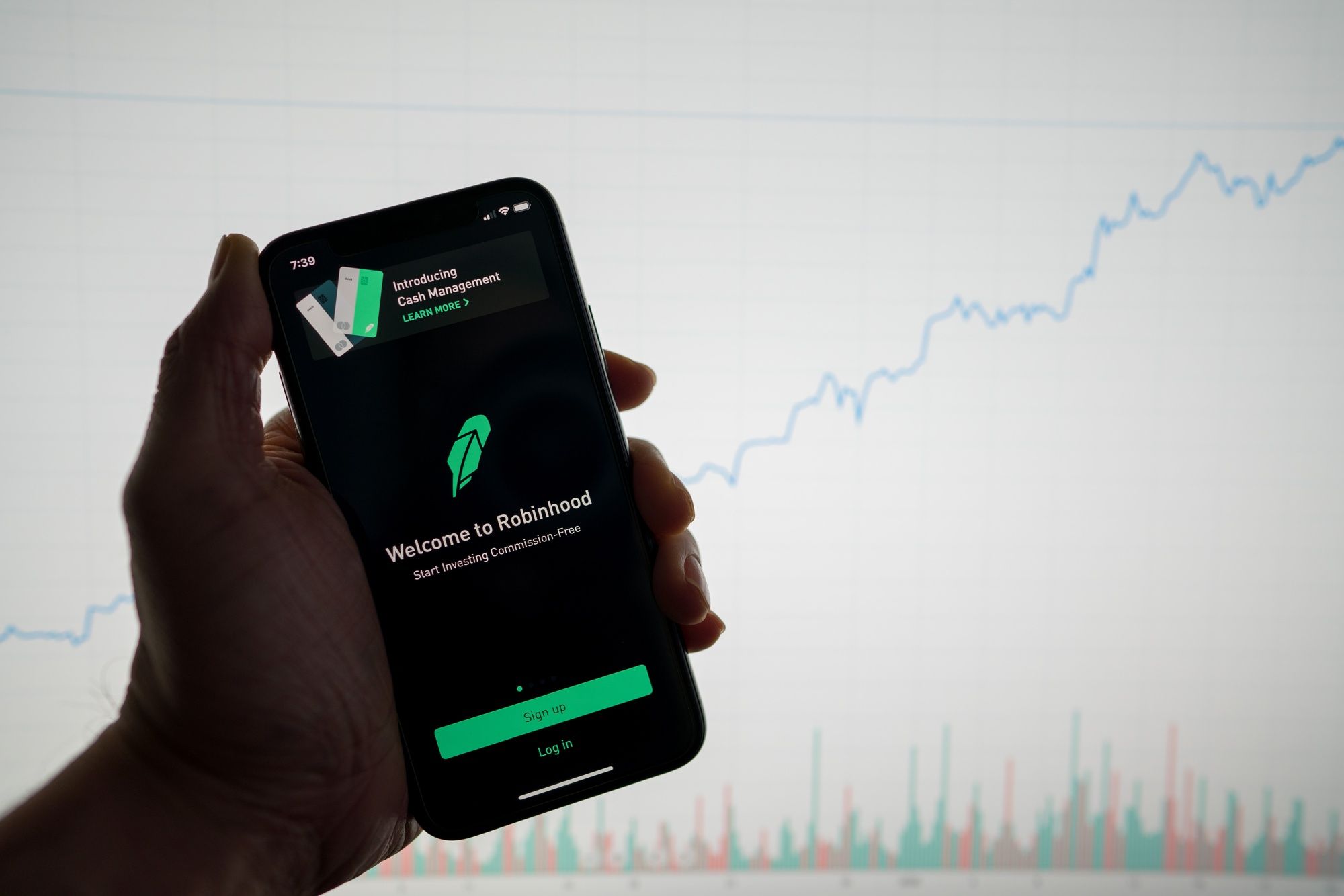 Person holding phone showing Robinhood app