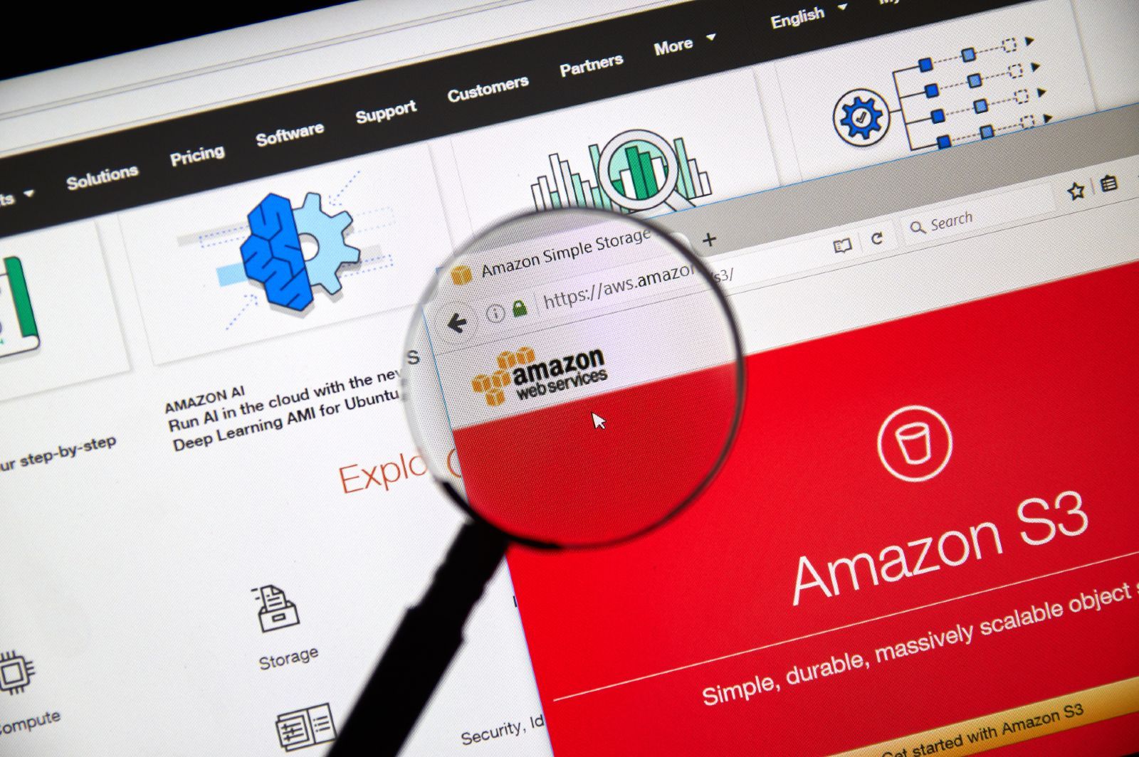 Amazon Web Services logo on the webpage is seen under a magnifying glass - Parler app
