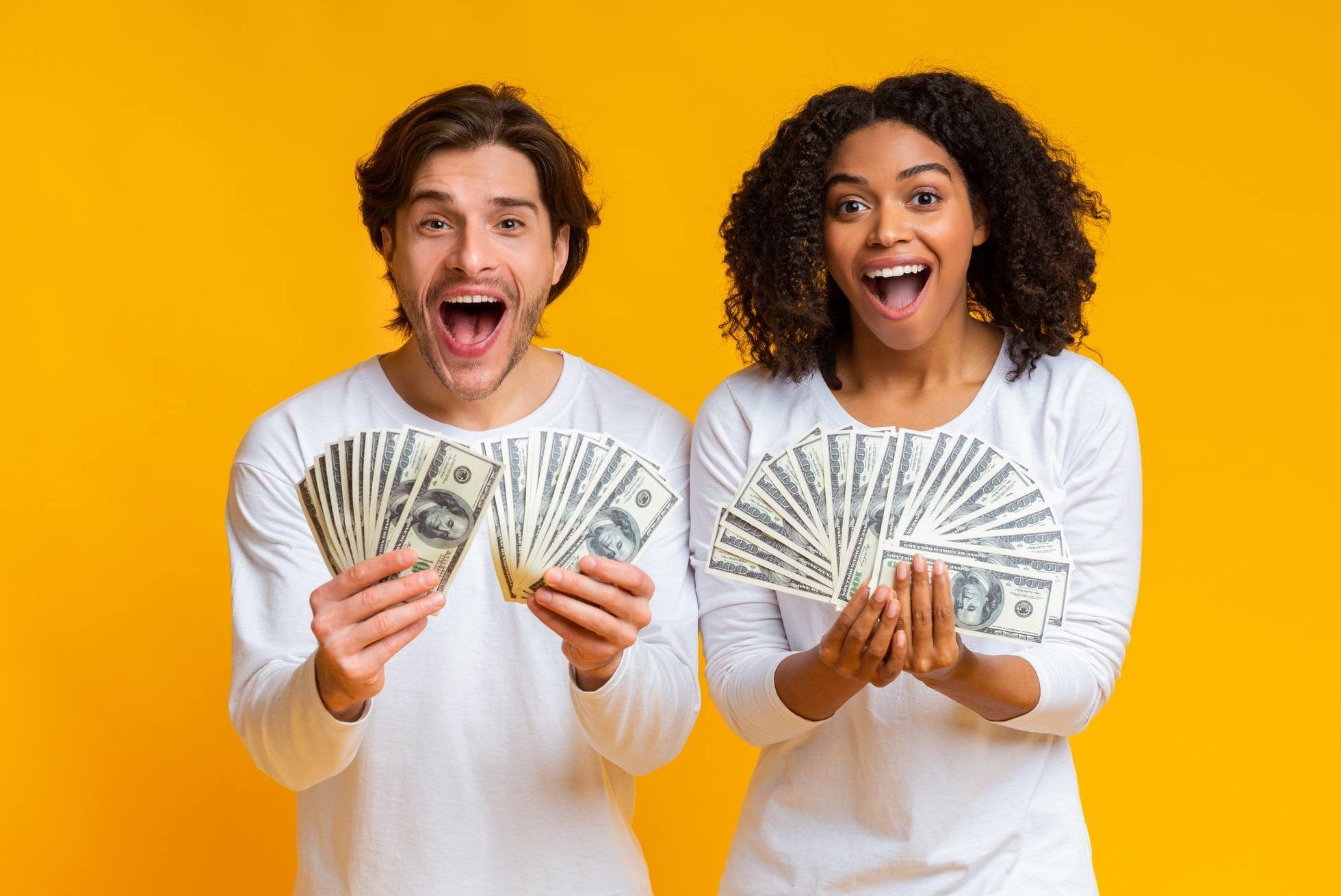 A man and woman hold fanned-out cash at arm's length in front of them as they stand against a yellow background, representing June settlement deadlines.