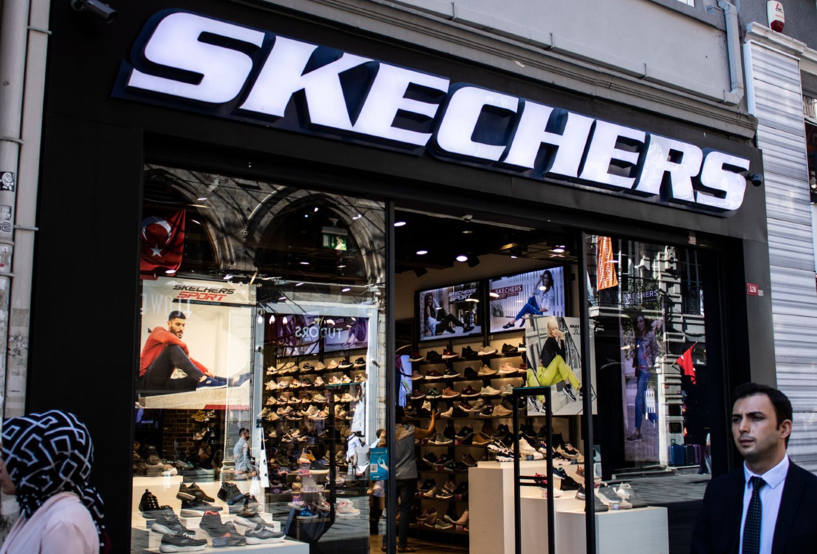 People walk past a Skechers store - Skechers light-up shoes