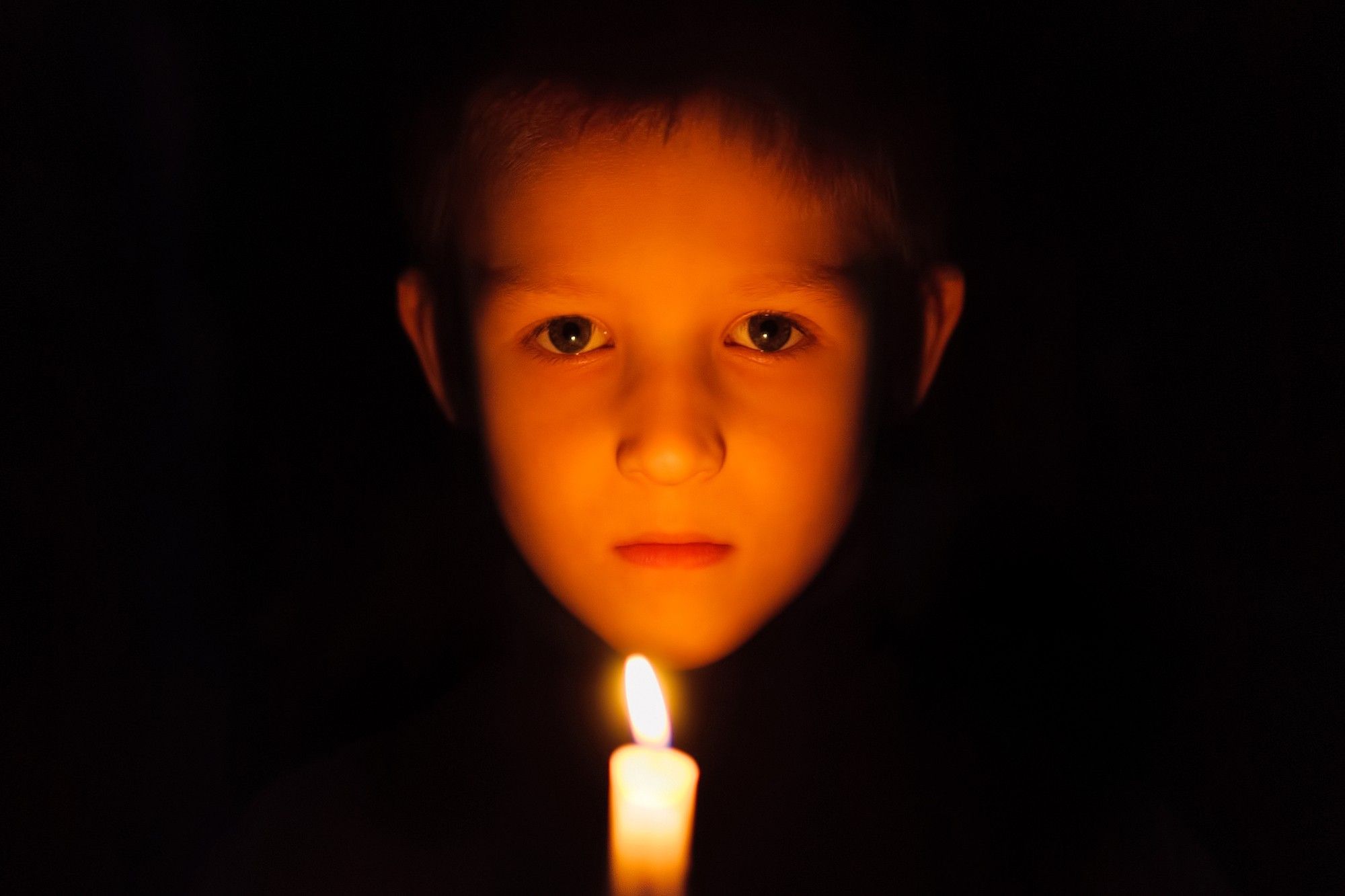 child and candle in power outage