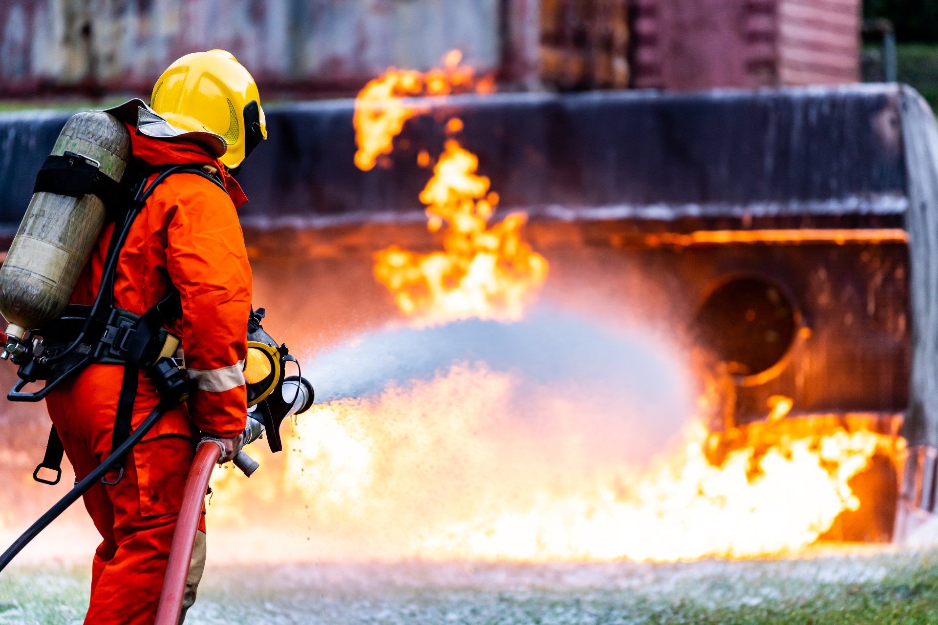 A firefighter uses firefighting foam to extinguish an oil tanker fire