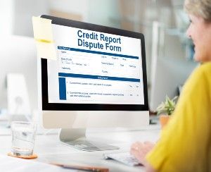 A woman fills out an online credit report dispute form - transunion