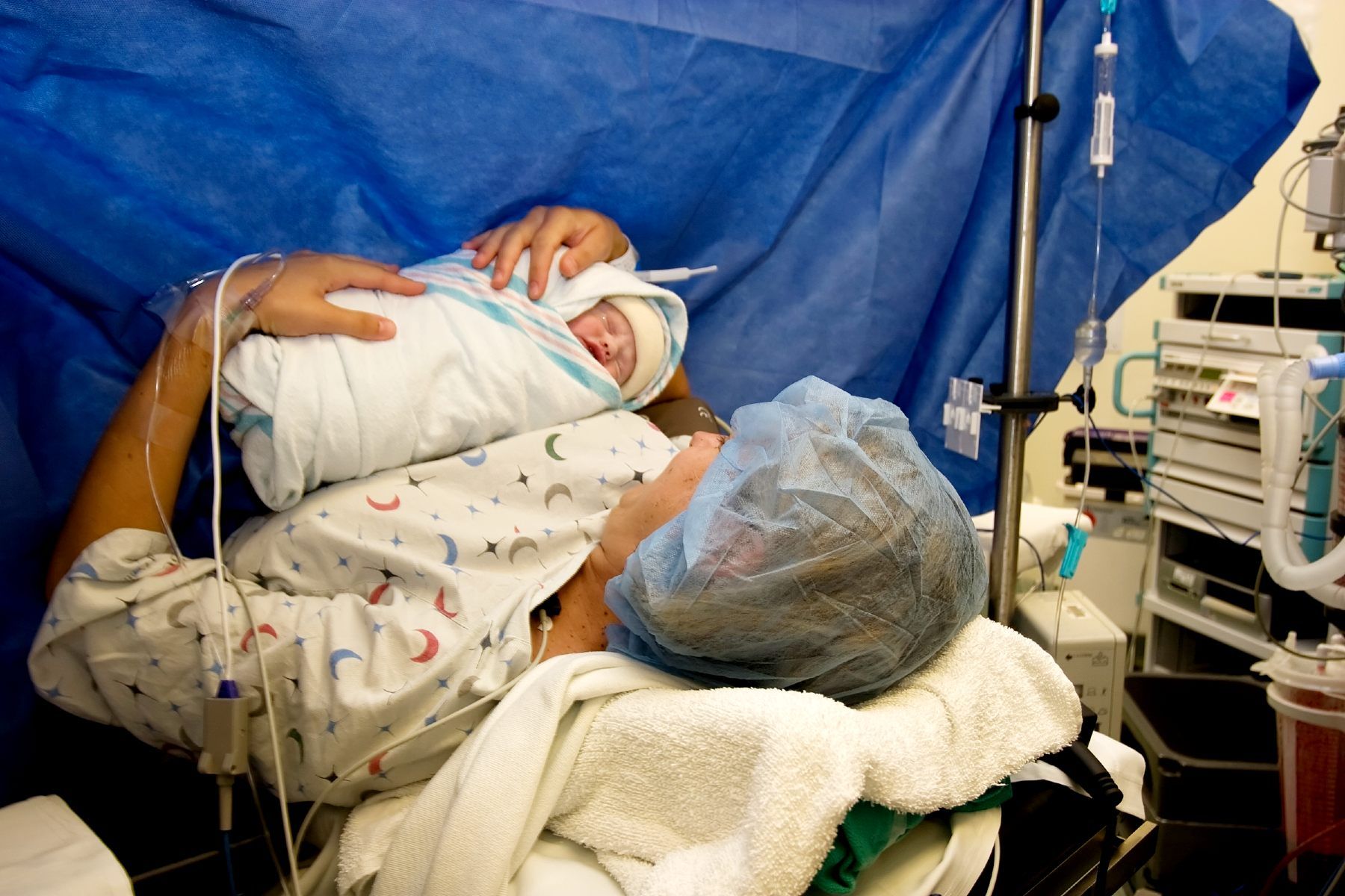 A mother examines her newborn baby in the delivery room - birth injury lawsuit