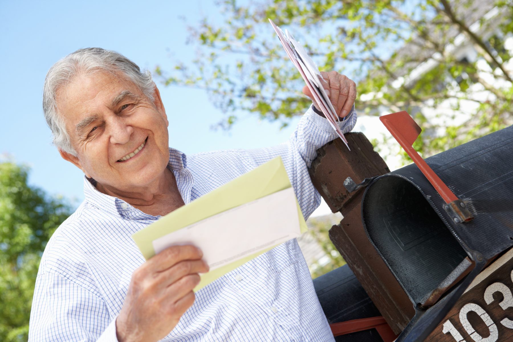 A happy man with gray hair checks his mail - FTC refunds