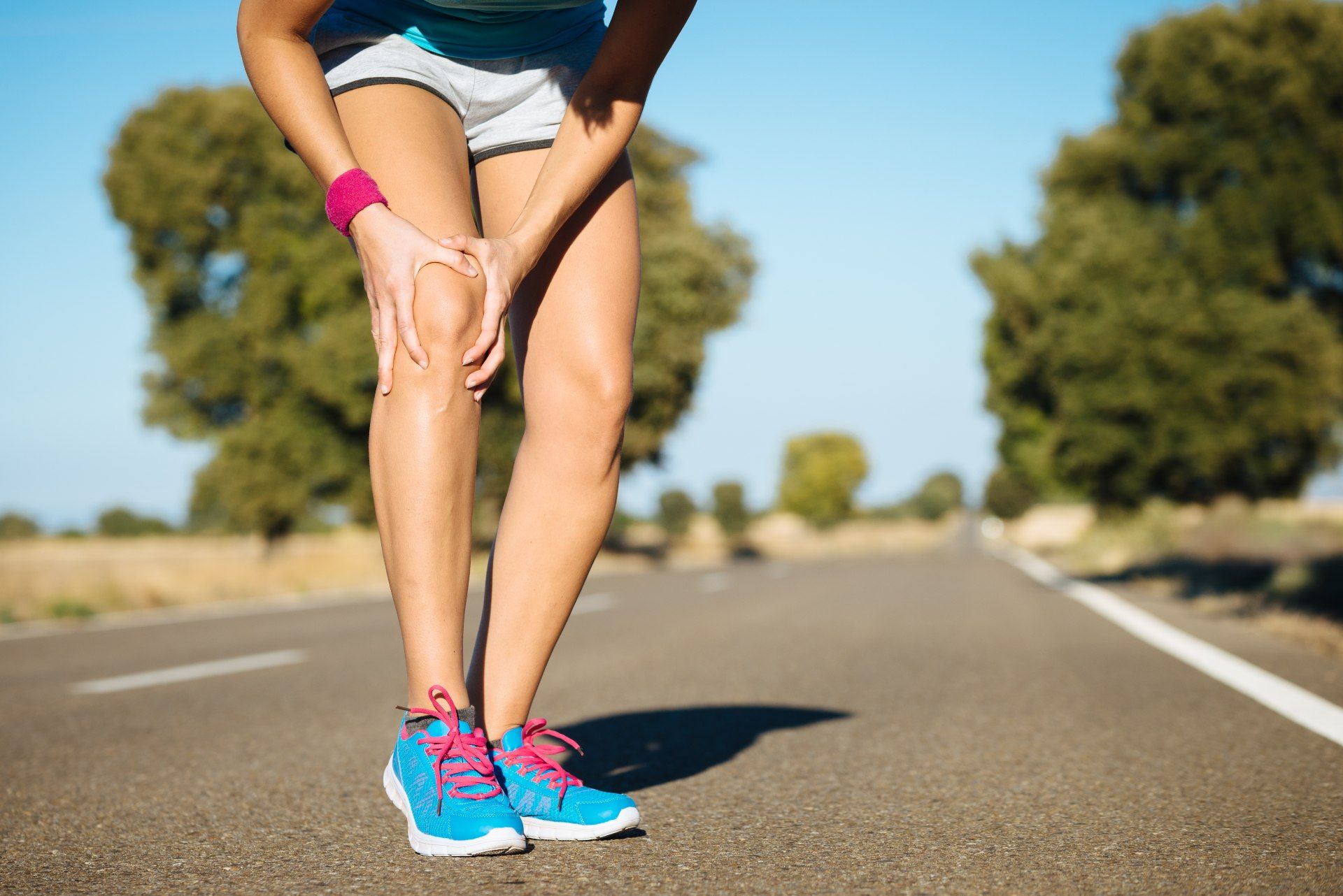 A runner grabs her knee in pain - move free supplements
