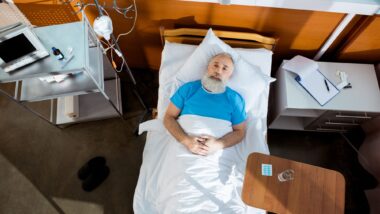 elderly sick man alone in bed