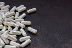 Off-white supplements on a dark grey surface - walmart glucosamine joint supplements