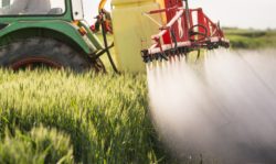tractor spraying fields with herbicide
