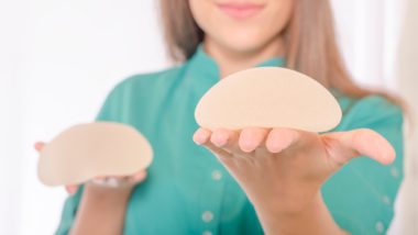 A woman holds two breast implants - allergan