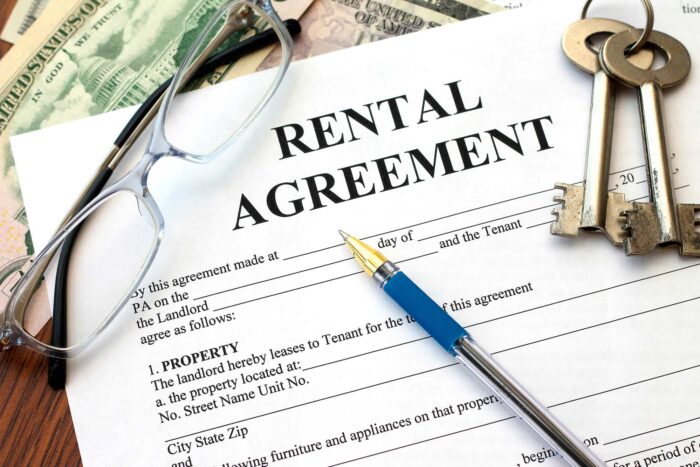 Rental agreement paperwork with glasses, pen and keys - rental application fees - lincoln property co. - lpc settlement - lpc lawsuit - lincoln property apartments