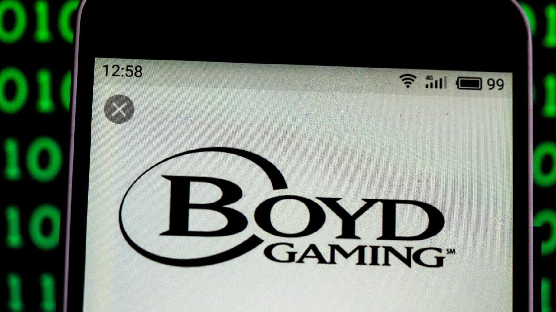 Boyd Gaming logo on smartphone against binary code background