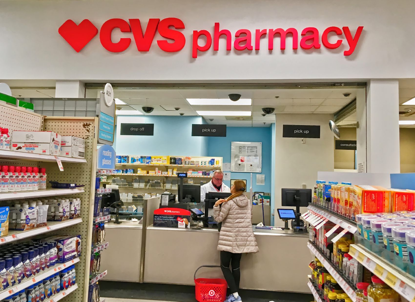 A woman speaks to a pharmacist at a CVS Pharmacy - CVS Pharmacy employees - overtime wages