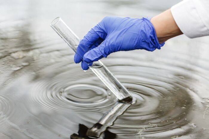 Researcher holds a test tube with water in a hand in blue glove - 3m - georgia-pacific llc - pfas water contamination