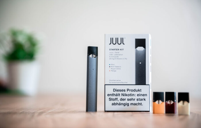 A JUUL Starter Kit on a table. juul, altria, and class action