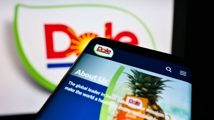 Cellphone with webpage of agriculture business company Dole plc on screen in front of logo.