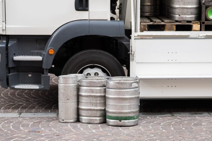 Beer kegs lined up outside delivery truck - late fees settlement