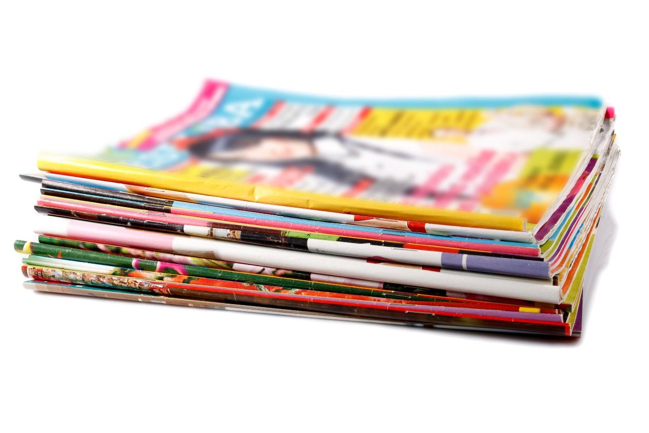 a stack of old colored magazines on white