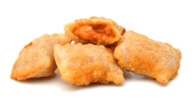 A serving of bite size pizza rolls isolated on a white background.