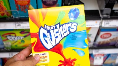 A hand holds a Fruit Gushers candy snack at the grocery store