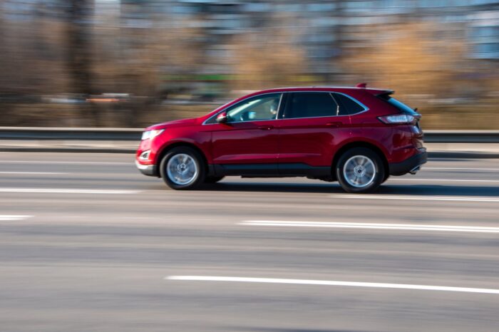 Red Ford Edge car moving on the street;