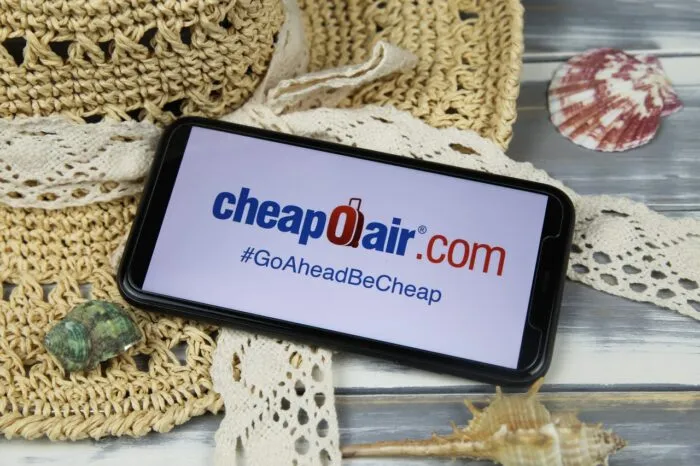 Closeup of smartphone with logo lettering of cheapoair.com travel agency w