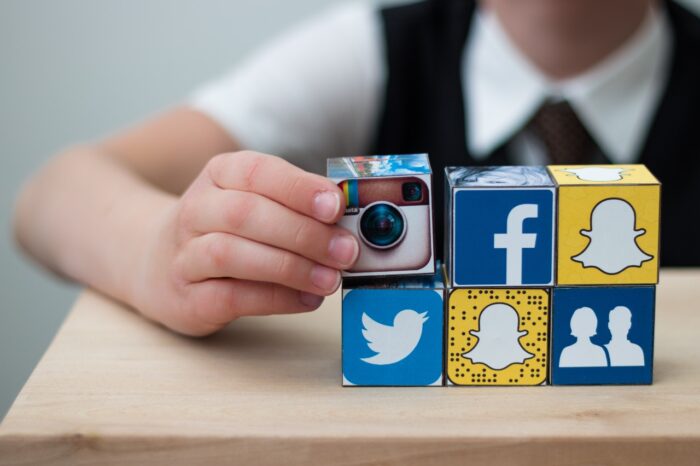 Teenager boy folds cubes with the logo of popular social networks.