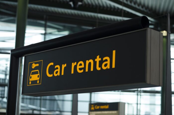 Sign with direction to car rental - Travelers lawsuit