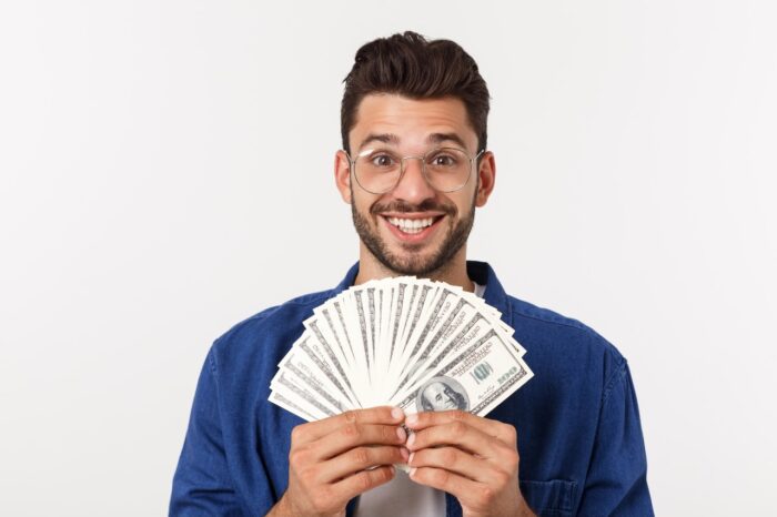 man is holding cash money in one hand, on isolated white background