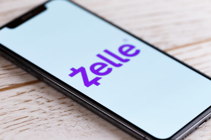 Zelle Apple Application Apps on Iphone Screen on a Rustic White Wooden Table.