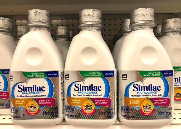 Grocery store shelf with jugs of Similac brand Pro-Advance infant formula.