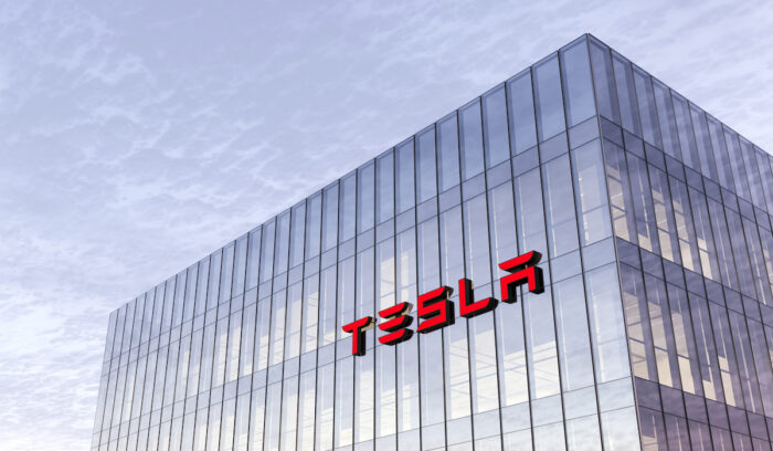 Tesla Signage Logo on Top of Glass Building. Workplace Car Company Office Headquarter.
