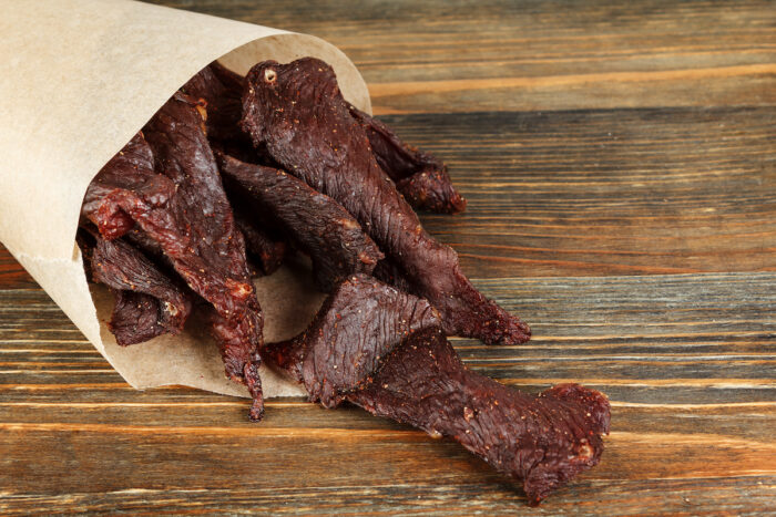 Beef jerky on a wooden board close-up.