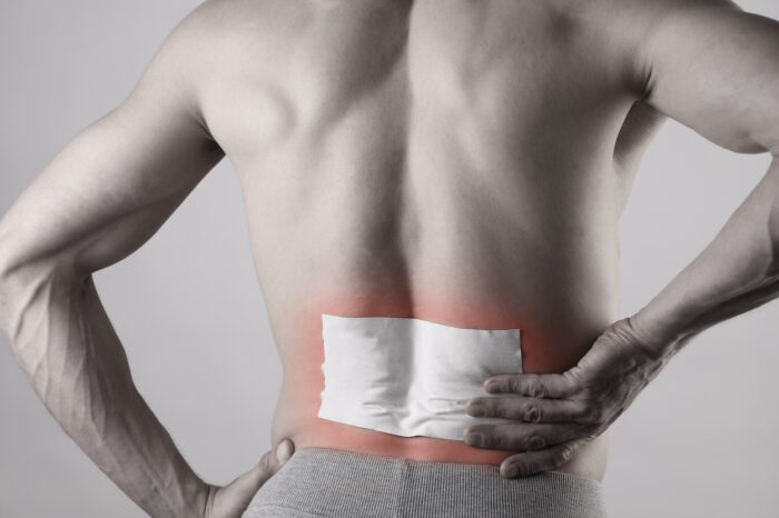 Medicated pain relief patch, plaster. man with back pain.