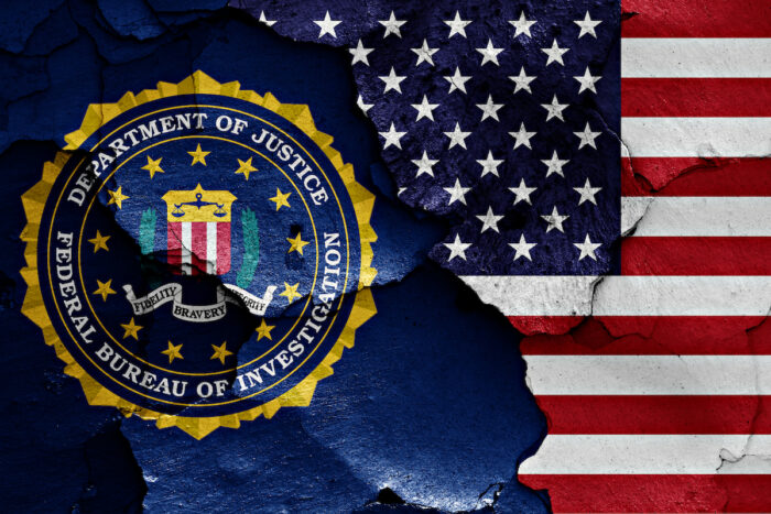 Flag of FBI and USA painted on cracked wall.