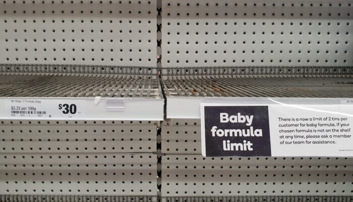 Empty baby formula shelves at a supermarket due to high demand.