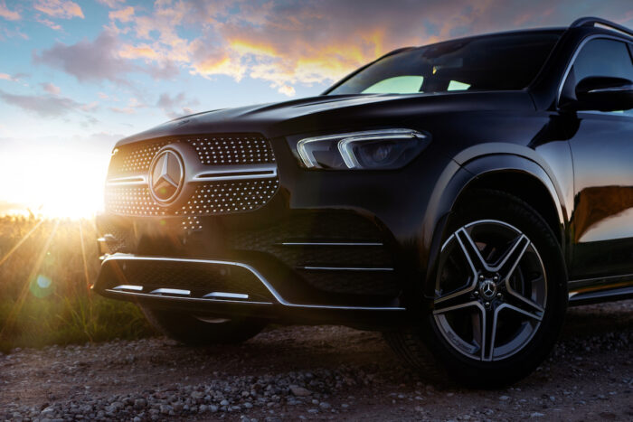 Photo of Mercedes SUV against a sunset sky.